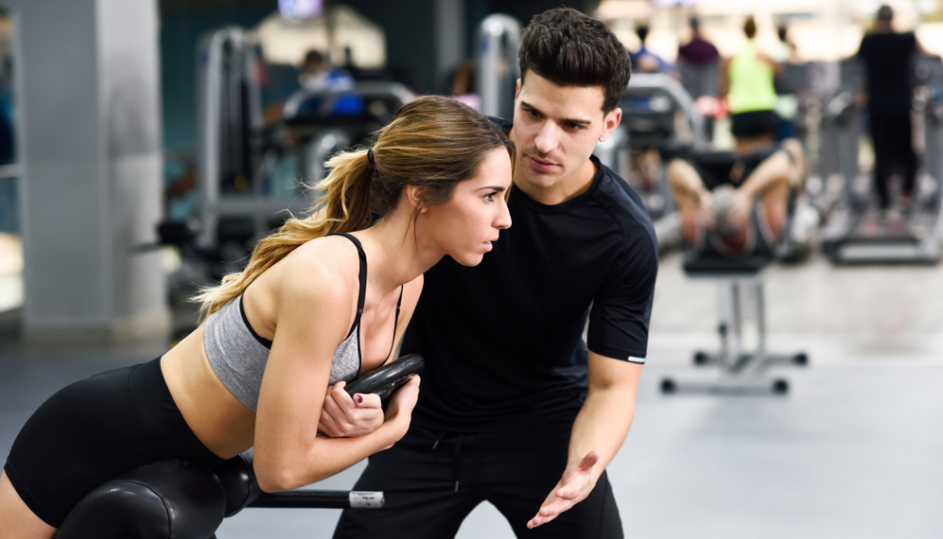 Homme coachant une femme en salle de fitness et musculation. Studio Fit, le club de sport qui vous coach